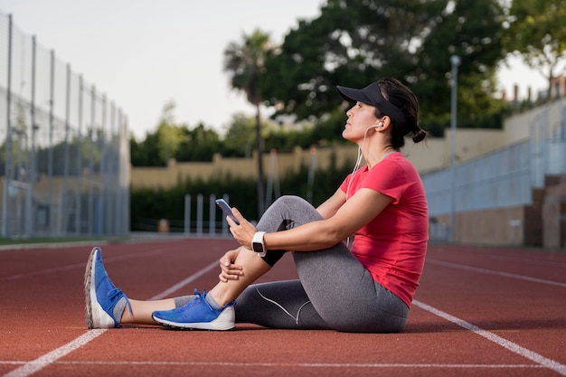 Mujer de ángulo bajo descansando después de correr