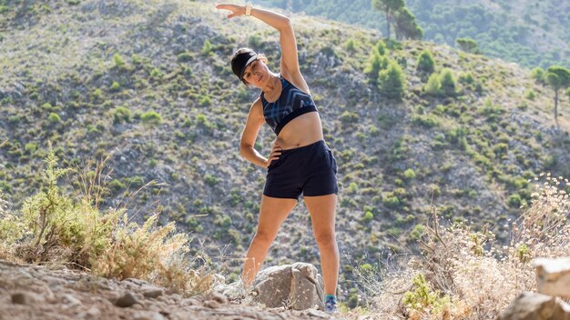 Mujer de ángulo bajo en ejercicio de la naturaleza