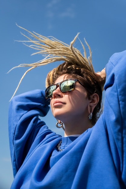 Mujer de ángulo bajo con gafas de sol