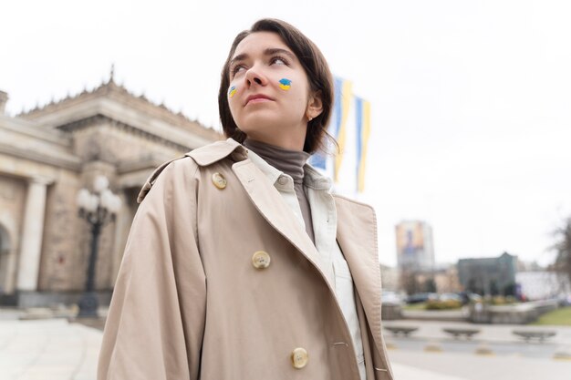 Mujer de ángulo bajo con pintura facial