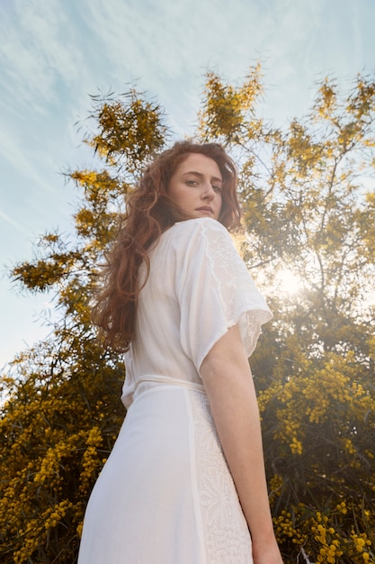 Mujer de ángulo bajo posando al aire libre