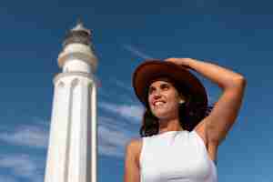 Foto gratuita mujer con ángulo bajo posando con faro