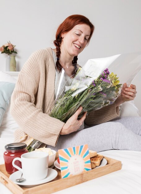 Mujer de ángulo bajo con ramo de flores