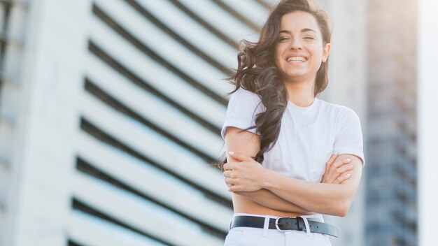 Mujer de ángulo bajo en ropa blanca posando