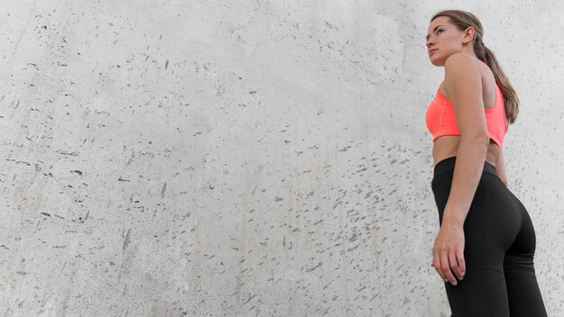 Mujer de ángulo bajo con ropa deportiva con espacio de copia