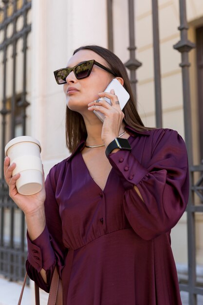 Mujer de ángulo bajo, tenencia, taza de café