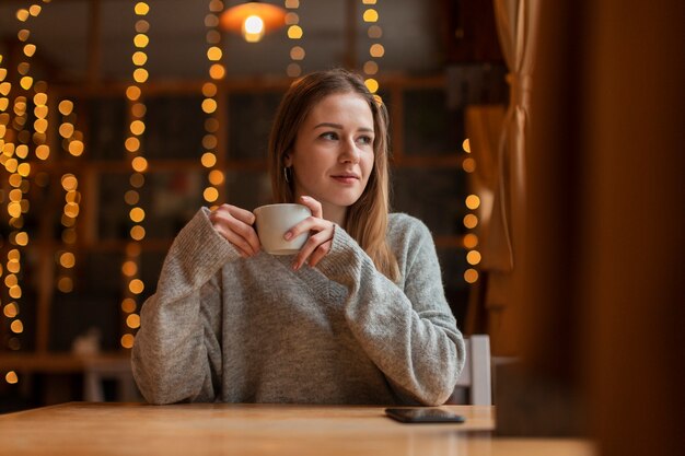 Mujer de ángulo bajo tomando café