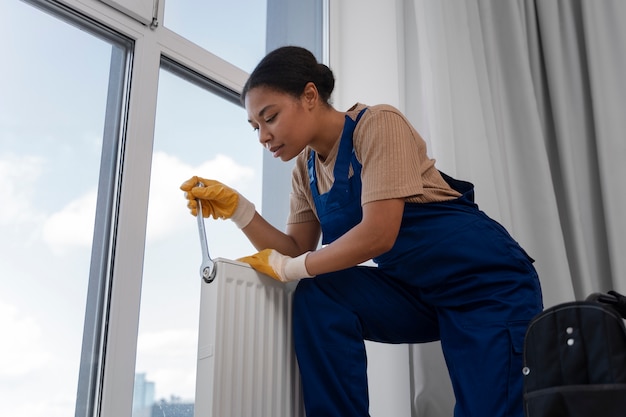 Foto gratuita mujer de ángulo bajo trabajando como fontanero