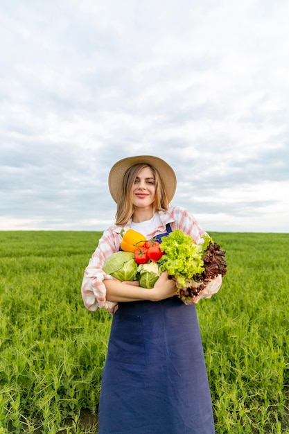 Foto gratuita mujer de ángulo bajo con verduras