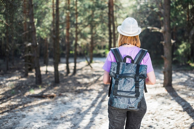 Mujer anónima caminando en el bosque