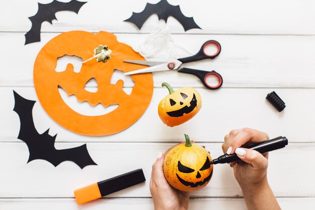 Mujer anónima creando calabazas para Halloween