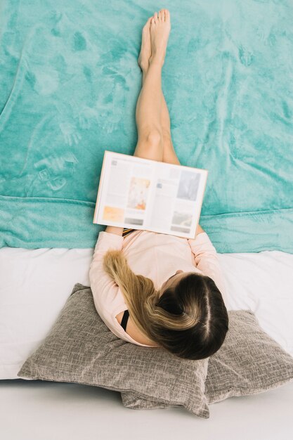 Mujer anónima leyendo en la cama