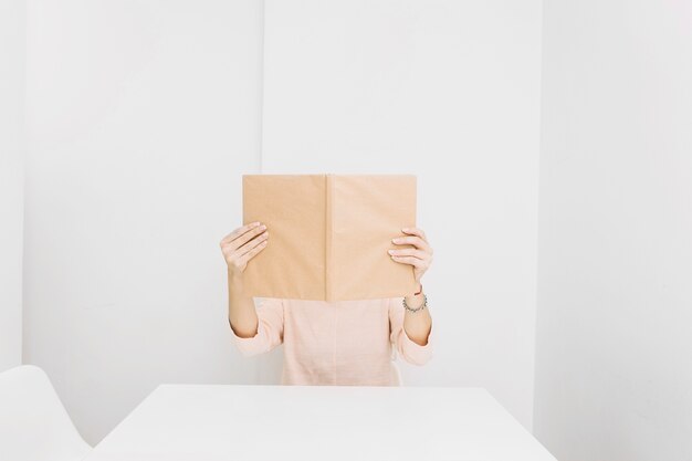 Mujer anónima leyendo en la mesa