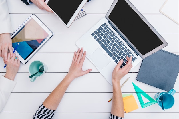 Foto gratuita mujer anónima que muestra la computadora portátil a los colegas