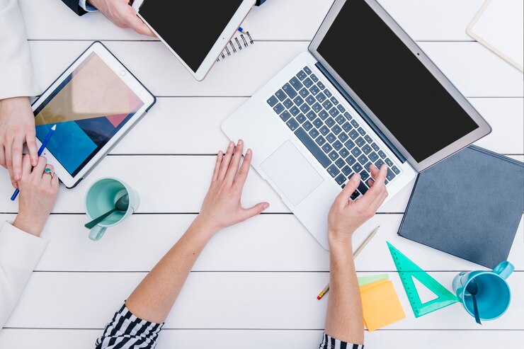 Foto gratuito mujer anónima que muestra la computadora portátil a los colegas