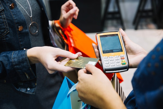 Foto gratuita mujer anónima que paga en la tienda