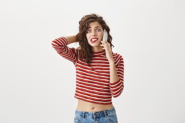 Mujer ansiosa preocupada hablando por teléfono, mirando nerviosa