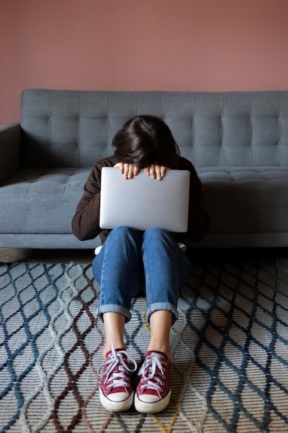 Foto gratuita mujer ansiosa de tiro completo con laptop