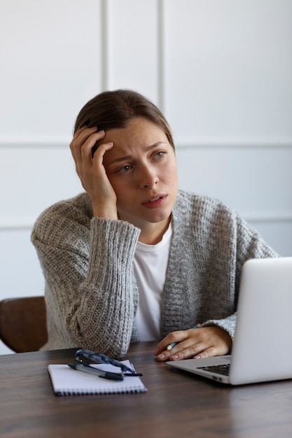 Foto gratuita mujer ansiosa de tiro medio en el escritorio