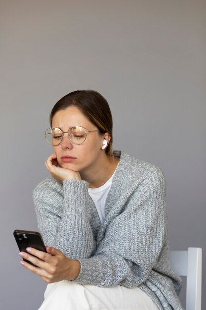 Mujer ansiosa de tiro medio con teléfono inteligente