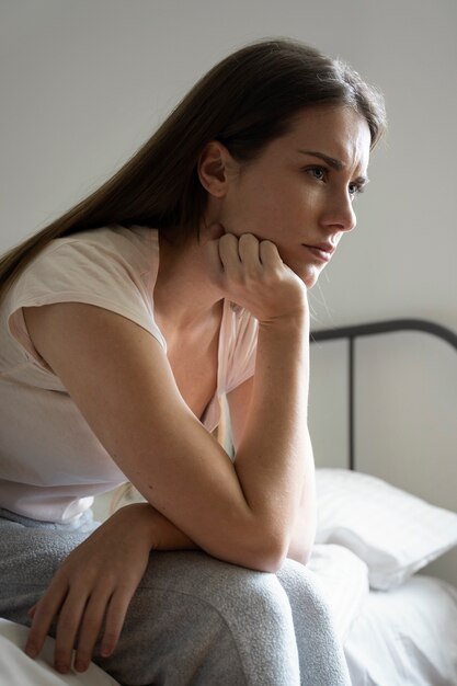 Mujer ansiosa en vista lateral de la cama