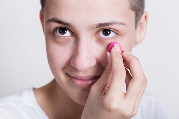 Mujer aplicando crema para ojeras