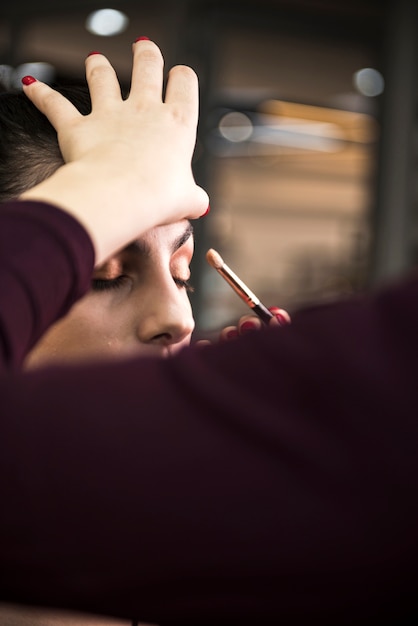 Mujer aplicando maquillaje en modelo