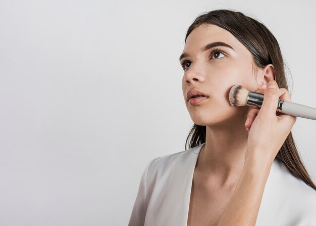 Mujer aplicando maquillaje en modelo