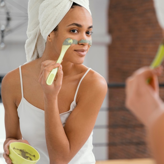 Mujer aplicando una mascarilla casera en su rostro