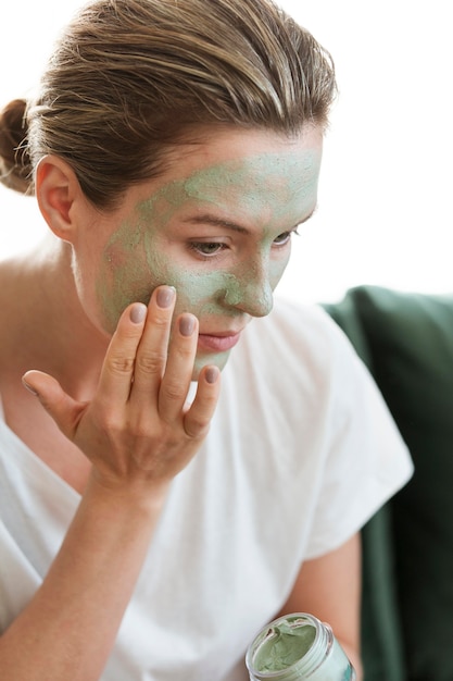 Mujer aplicando mascarilla facial orgánica