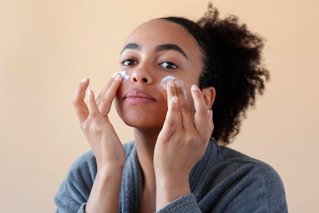 Mujer aplicar crema facial de cerca