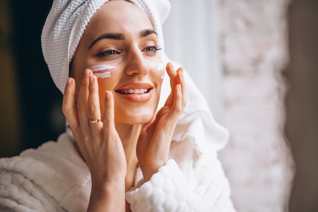 Mujer aplicar crema facial