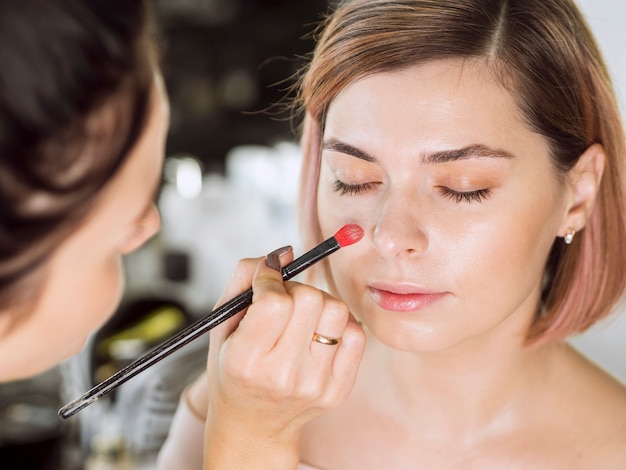 Mujer aplicar maquillaje con brocha