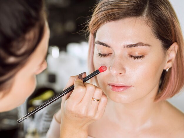 Mujer aplicar maquillaje con brocha