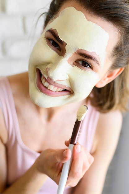 Foto gratuita mujer aplicar mascarilla a sí misma