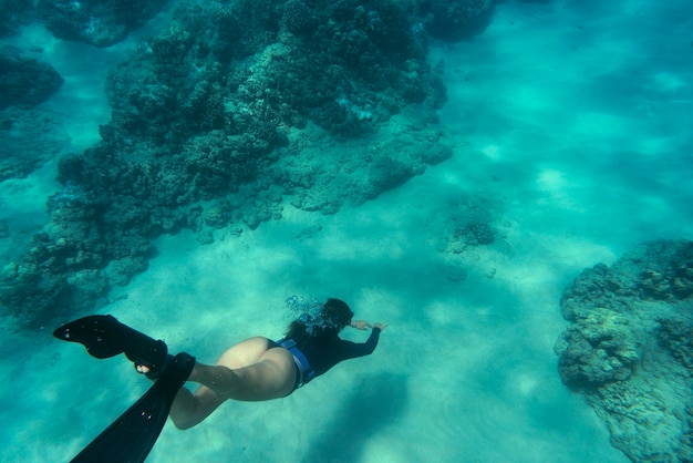 Foto gratuita mujer apnea con aletas bajo el agua