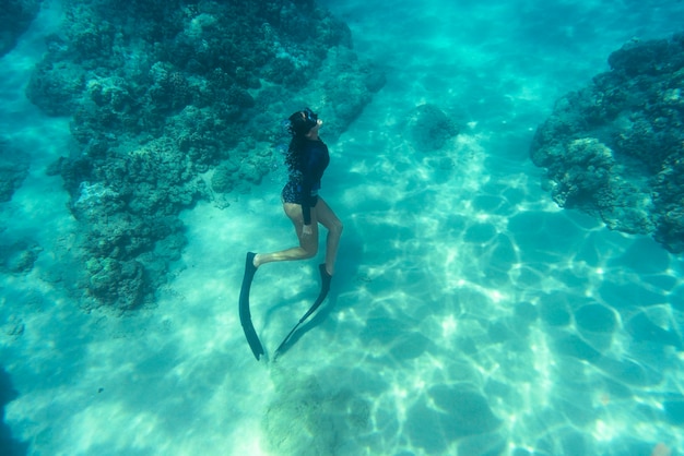 Foto gratuita mujer apnea con aletas bajo el agua