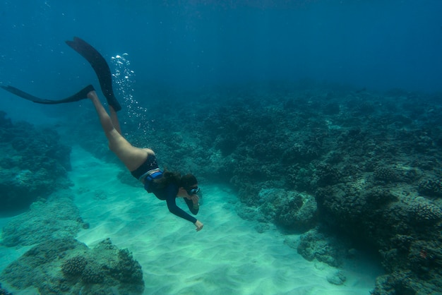 Mujer apnea con aletas bajo el agua