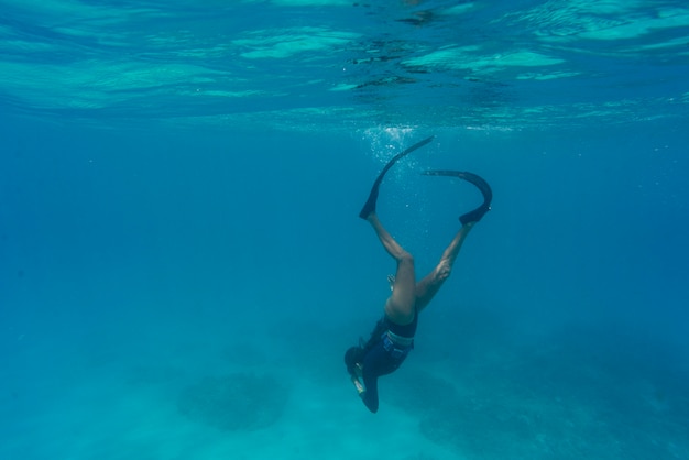 Mujer apnea con aletas bajo el agua