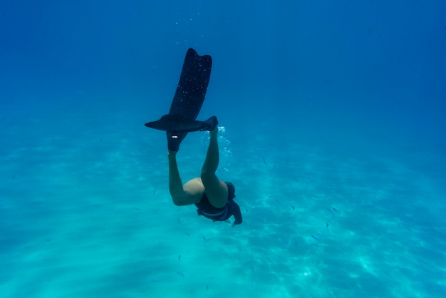 Mujer apnea con aletas bajo el agua