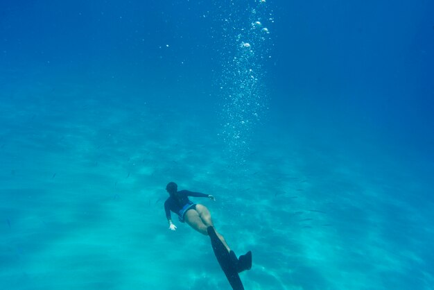 Mujer apnea con aletas bajo el agua