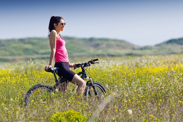 Mujer apta que monta la bici de montaña