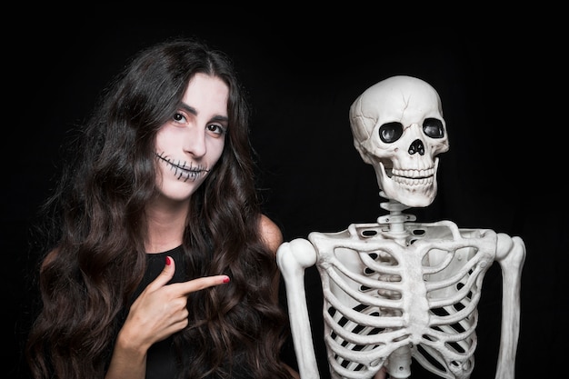 Mujer apuntando al esqueleto