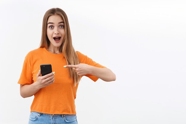 Mujer apuntando al teléfono inteligente