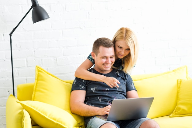 Foto gratuita mujer apuntando en la pantalla mientras que el hombre usa la computadora portátil