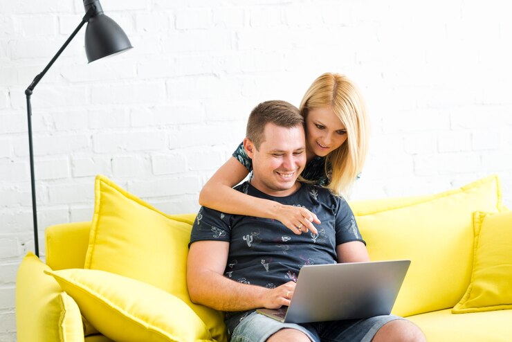 Foto gratuito mujer apuntando en la pantalla mientras que el hombre usa la computadora portátil