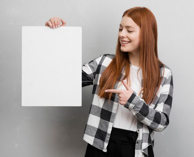 Mujer apuntando a la tarjeta en blanco