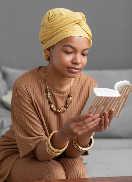 Mujer árabe relajada leyendo un libro en casa