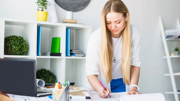 Mujer arquitecto dibujo blueprint en el lugar de trabajo