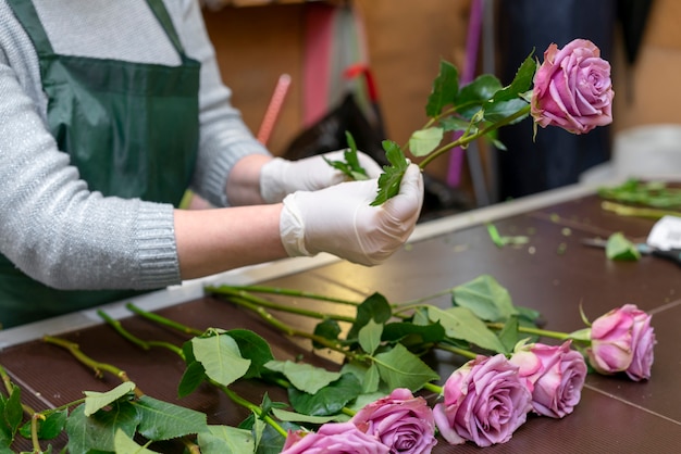 Mujer arreglando elegantes flores de color púrpura